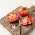 Tres Cantos tomato sliced on a wooden board showing firm, juicy red flesh – slicing tomato